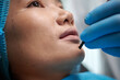 © DragonImages - Closeup image of plastic surgeon marking face of patient before chin filler injection