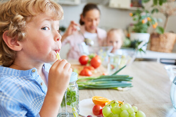 Playful boy sipping detox water from mason jar