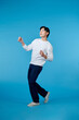 © makistock - young asian man dancing isolated on blue background