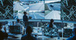 © Gorodenkoff - Male Software Engineer Working on Laptop Next to a Big Screen in a Modern Monitoring Office with Live CCTV Footage with Traffic Situation. Monitoring Room With Big Data Engineers Work on Computers