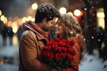 In Love Couple Kissing In Snow At City Street. Handsome Man And Beautiful Young Woman With Red Roses, Outdoors Portrait. Happy Valentine's Day.