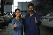Indian happy female customer showing a thumbs up for repairing the car. Portraying customer trust and satisfaction towards the service station