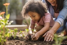 Mother And Daughter Planting Flowers Into Soil In House Backyard