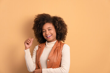 Wall Mural - close up portrait of african american woman smiling and looking at camera in beige studio background. portrait, real people concept.