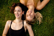 Two pretty young women laying on grass