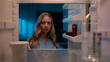 © Yuliia - Point of view POV inside refrigerator Caucasian girl hungry woman open fridge at home kitchen look at empty shelves order food products delivery with mobile phone app online service web store shopping