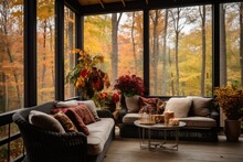 Screened Porch With Modern Furniture, Vase Of Flowers, Autumn Leaves And Woods In The Background, Creating A Cozy Atmosphere.