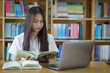 © EduLife Photos - Portrait of an Asian girl college student studying in library doing project assignment and preparing for examination