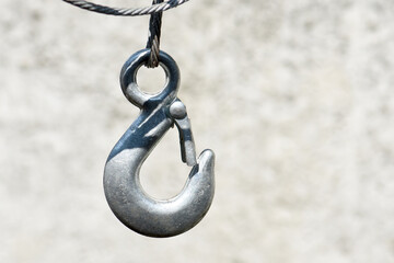 A steel hook hangs on a cable.