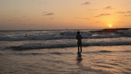 Poster - Happy teenager boys, running and playing on the beach on sunset, splashing water and jumping on the sand. Tel Aviv, Israel