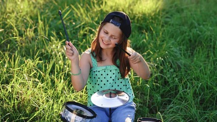 beautiful smiling happy young little girl with long hair playing on the drums. expressive drummer gi