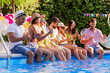 © ivanko80 - Friends sitting by poolside and drink beers while listening music