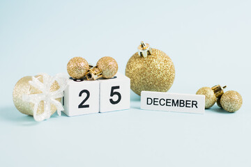 Christmas decor and wooden calendar with the date December 25 on a blue background. The concept of preparing for the celebration of Christmas and New Year and plans for the future.