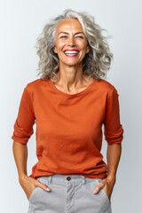 Canvas Print - Woman with grey hair and smile on her face is standing with her hands in her pockets.