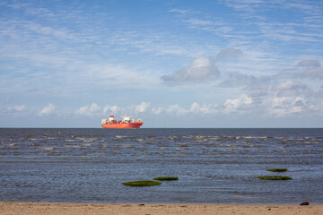 Large cargo ship on the North sea in Germany. View from the beach.