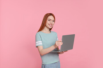 Canvas Print - Smiling young woman with laptop on pink background