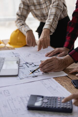 A team of engineers and architects, men and women working together, discussing design, planning, measuring the layout of blueprints in offices, construction sites. Portrait Picture