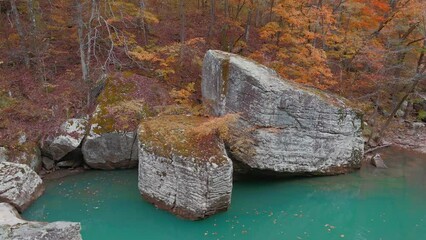 Wall Mural - Large rock boulder in beautiful turquoise pool of water in Arkansas ozark mountain creek via aerial drone in autumn