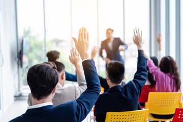 Business person raising hand during seminar. Hand up in conference asking to answer a question in business meeting room and seminar class.