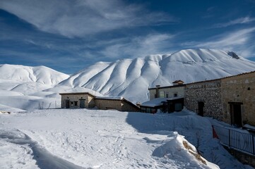 Poster - Landscape of sow covered white peaks of majestic mountains in Castelluccio di Norcia in wintertime