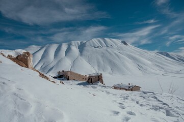 Poster - Landscape of sow covered white peaks of majestic mountains in Castelluccio di Norcia in wintertime