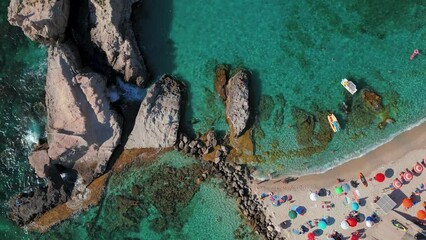 Wall Mural - Drone shot of blue crystal water with Bay of Riaci in Calabria cliffs view