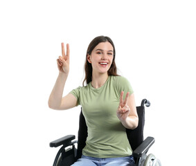 Wall Mural - Young woman in wheelchair showing victory gesture on white background