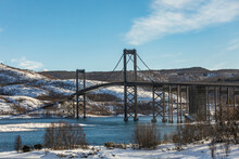 Suspension Bridge Over River In Winter Day