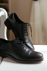 Canvas Print - Isolated shot of a pair of shoes on top of a wooden table with a white chair in the background