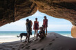 © Luis Herrera/Stocksy - Family and Dog Exploring an Ocean Cave on a Beach Vacation Adventure
