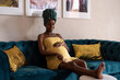 © Milles Studio/Stocksy - Smiling black future mother massaging leg