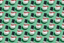 Seamless Pattern Made With Funny Snowmen On Green Background