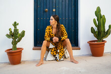 Female Flamenco Dancer Resting At Doorstep Of House