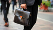 © PaulShlykov - Detail of a businessman holding a leather briefcase. Wide image with large copy space