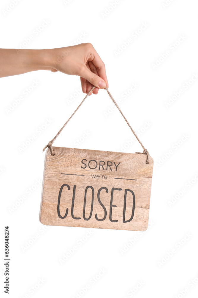 Female hand holding sign with text SORRY WE'RE CLOSED on white background