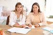 © Pixel-Shot - Female students studying at table in dorm room