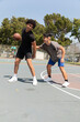 © Jordana Sheara/Stocksy - Teenagers playing basketball at an outdoor neighborhood park