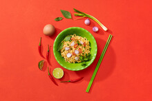 A Bowl With Ready Instant Noodles And Chopsticks On Red Background.