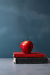 Back to school chalkboard background with a red apple and couple of books lots of copy space
