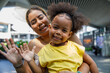© Jovo Jovanovic/Stocksy - Cheerful mother with daughter waving hand and greeting to the camera