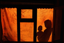 A Silhouette Of A Mother Holding Her Baby In Front