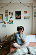 © BONNINSTUDIO/Stocksy - Woman recording a podcast on bedroom