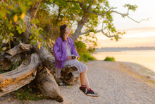 Woman Sitting On The Log And Looking At Sea Waiting To Photograph 