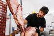 © Ezequiel Giménez/Stocksy - Man cutting piece of raw meat with knife