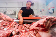 © Ezequiel Giménez/Stocksy - Male butcher taking raw meat from fridge