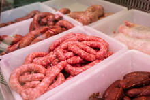 Various Raw Sausages Placed In Boxes On Market Stall