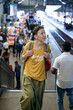 © AD Astra Team/Stocksy - A female traveler at a railway station in Asia
