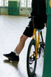 © Nikita Sursin/Stocksy - Closeup of man’s legs standing inform of yellow bicycle