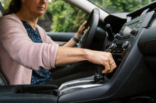 Middle Aged Woman In Car Putting The Vehicle Into Gear To Drive