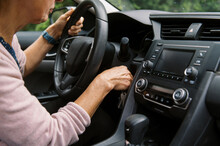 Middle Aged Woman Turning Key In Ignition 